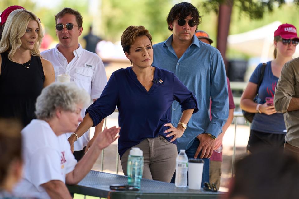 Gubernatorial candidate Kari Lake listens as Tyler Bowyer, chief operating officer of Turning Point Action, introduces her at South Mountain Pavilion at Tumbleweed Park in Chandler on Aug. 27, 2022.