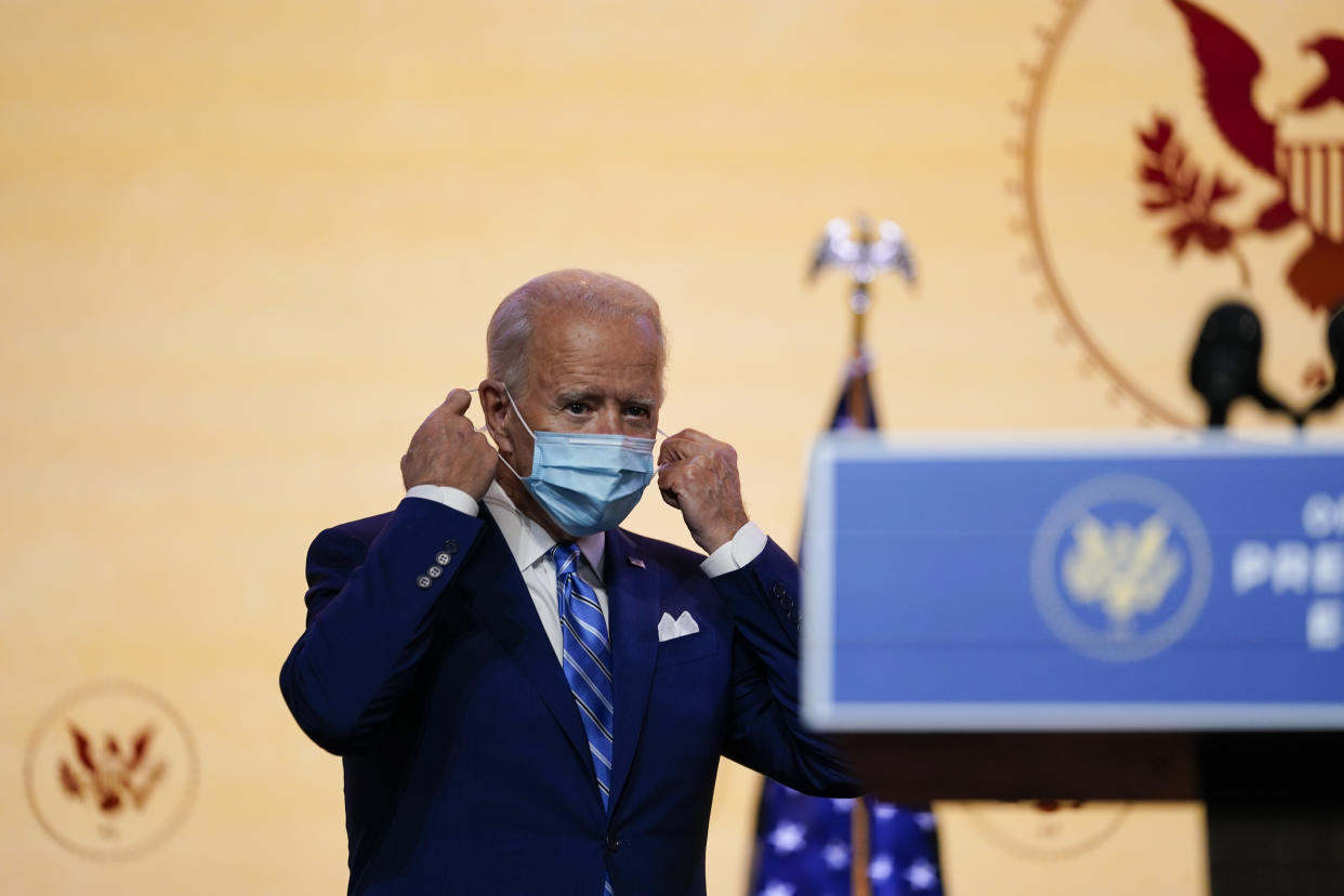 President-elect Joe Biden removes his face mask before speaking Wednesday, Nov. 25, 2020, in Wilmington, Del. (AP Photo/Carolyn Kaster)