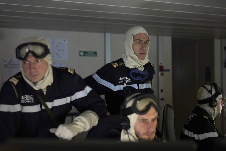 The commanding officer of the French navy frigate Normandie, Capt. Thomas Vuong, right, oversees operations in the vessel's combat information center as the vessel patrols in a Norwegian fjord, north of the Arctic circle, for a reconnaissance patrol, Wednesday March 6, 2024. The French frigate is part of a NATO force conducting exercises in the seas, north of Norway, codenamed Steadfast Defender, which are the largest conducted by the 31 nation military alliance since the cold war.(AP Photo/Thibault Camus)