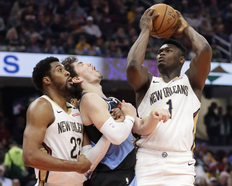 New Orleans Pelicans' Zion Williamson, right, shoots against Cleveland Cavaliers' Cedi Osman, center, during the second half of an NBA basketball game Tuesday, Jan. 28, 2020, in Cleveland. Derrick Favors, left, watches. (AP Photo/Tony Dejak)