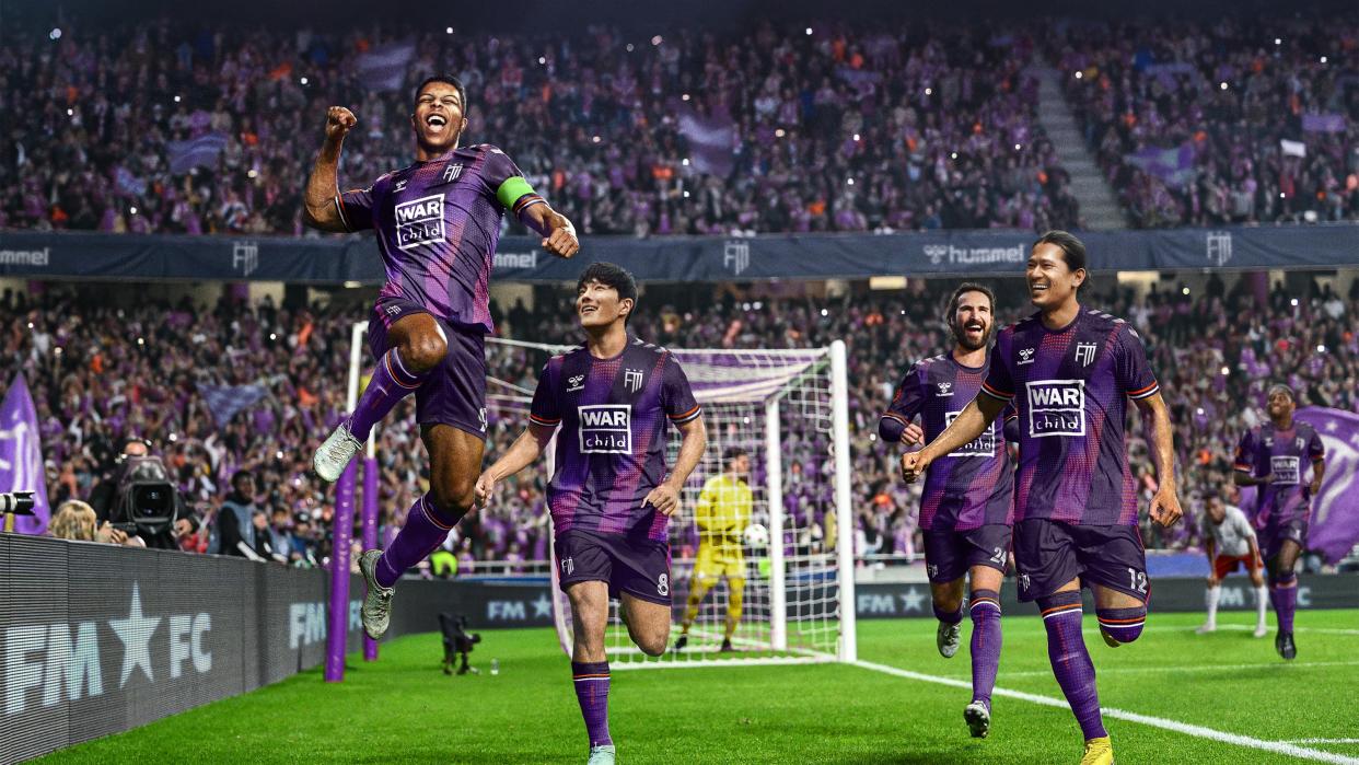  Players celebrate scoring a goal in the Football Manager 24 key art. 