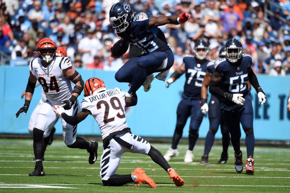 Titans tight end Chigoziem Okonkwo attempts to hurdle Bengals cornerback Cam Taylor-Britt after a reception during the first half at Nissan Stadium in Nashville on Oct. 1, 2023.