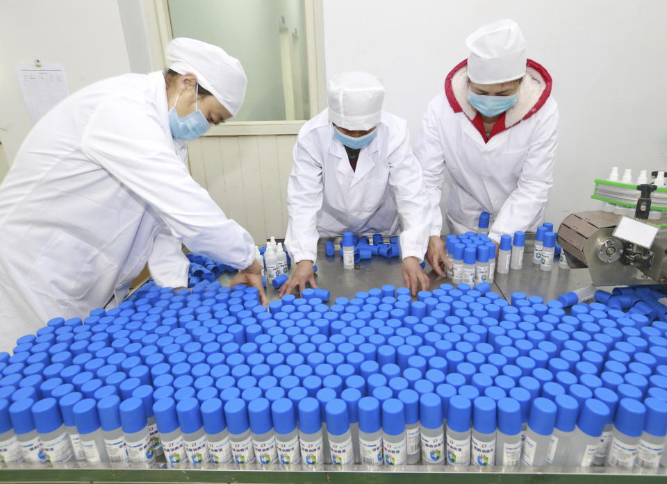Workers pack bottles of alcohol disinfectant in a factory in Suining in southwest China's Sichuan province Tuesday, Feb. 11, 2020. China's daily death toll from a new virus topped 100 for the first time and pushed the total past 1,000 dead, authorities said Tuesday after leader Xi Jinping visited a health center to rally public morale amid little sign the contagion is abating. (Chinatopix Via AP) CHINA OUT