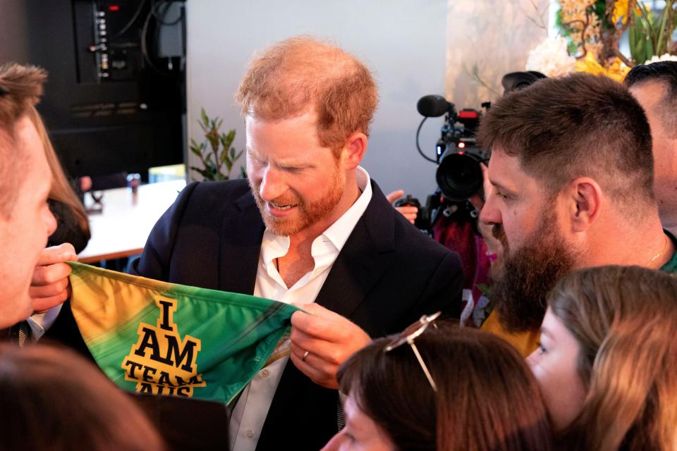 Prince Harry stretches the waistband of the swim briefs gifted by Team Australia at the Invictus Games as if to check they're his size.