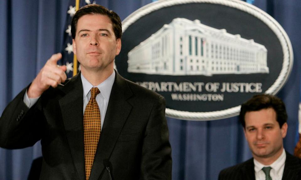 Christopher Wray, who was then assistant attorney general, sits behind James Comey at a news conference in 2004.