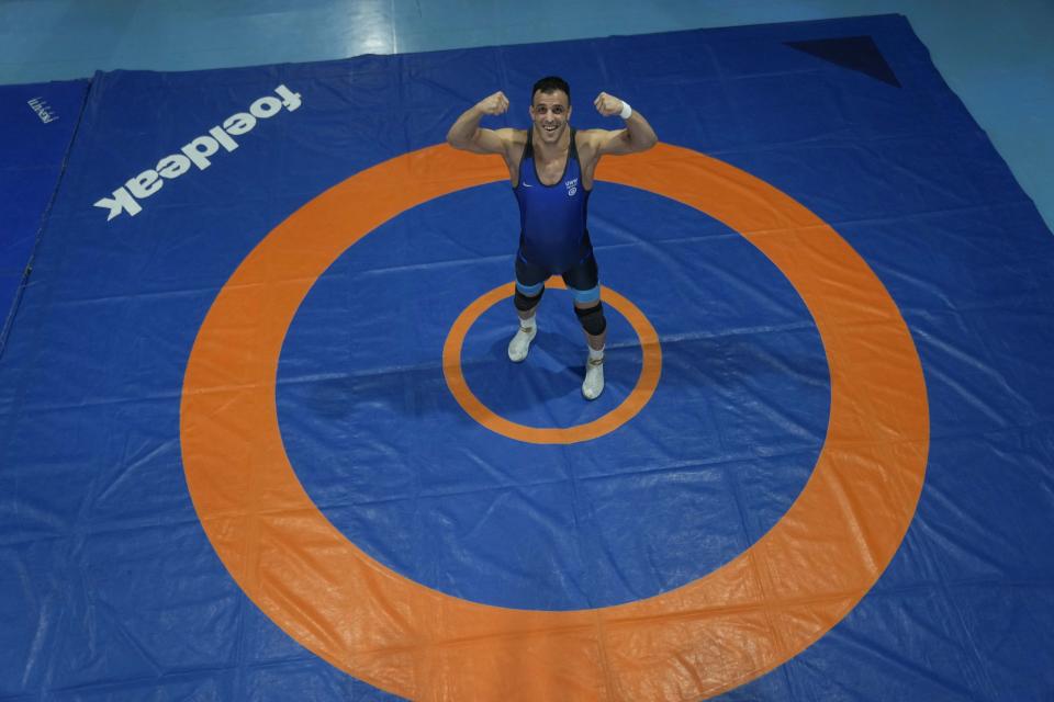 Iranian wrestler Iman Mahdavi, 28, a member of the Refugee Team for the Paris Olympics, poses at the Lotta Club Seggiano gym, in Pioltello, near Milan, Italy, Wednesday, Feb. 28, 2024. The Refugee Team for the Paris Olympics will feature 36 athletes from 11 countries in 12 sports. International Olympic Committee president Thomas Bach says the team was selected from more than 70 scholarships. Instead of competing under the Olympic flag, the refugees will have their own emblem featuring a heart at its center surrounded by arrows. (AP Photo/Luca Bruno)