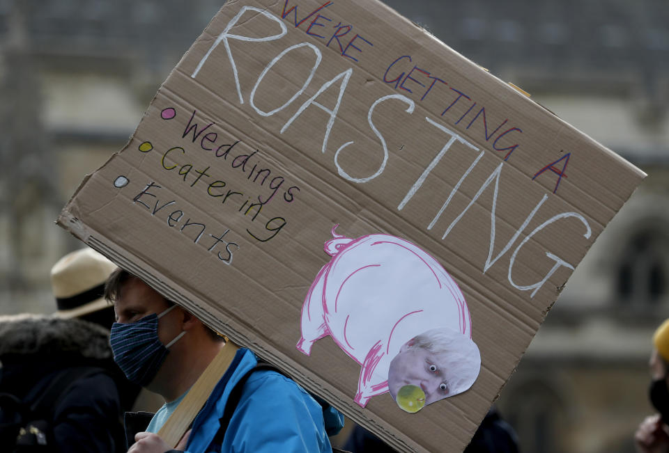 Hospitality workers protest in Parliament Square in London, Monday, Oct. 19, 2020. Hospitality workers are demonstrating outside Parliament against tougher coronavirus restrictions and the amount of financial support given by the government to the industry.(AP Photo/Frank Augstein)