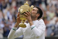 Serbia's Novak Djokovic kisses the winners trophy after he defeated Italy's Matteo Berrettini in the men's singles final on day thirteen of the Wimbledon Tennis Championships in London, Sunday, July 11, 2021. (AP Photo/Kirsty Wigglesworth)