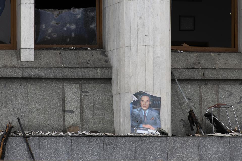 FILE - A portrait of former Kazakhstan President Nursultan Nazarbayev at the city hall building after clashes in the central square blocked by Kazakhstan troops and police in Almaty, Kazakhstan, Monday, Jan. 10, 2022. Kazakhstan’s influential former leader has released a short video in which he talked about the violent unrest that engulfed the ex-Soviet nation earlier this month. In it he also rejected reports alleging that he fled the country amid tensions with the current president. The video published Tuesday, Jan. 18, 2022 was the first time Nursultan Nazarbayev, who ran Kazakhstan for 29 years after it gained independence and kept an influential post after stepping down as president, spoke publicly about the protests and the bloodshed they descended into. (AP Photo/Vasily Krestyaninov, File)