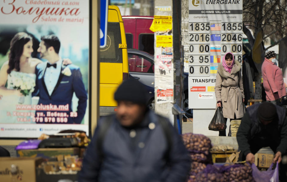 A woman walks through a street market in Comrat, Moldova, Saturday, March 12, 2022. Across the border from war-engulfed Ukraine, tiny, impoverished Moldova, an ex-Soviet republic now looking eagerly Westward, has watched with trepidation as the Russian invasion unfolds. In Gagauzia, a small, autonomous part of the country that's traditionally felt closer to the Kremlin than the West, people would normally back Russia, which they never wanted to leave when Moldova gained independence. (AP Photo/Sergei Grits)