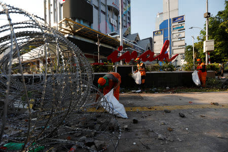 Workers collect trash as they clean the area after a riot across the Indonesia's Election Supervisory Agency (Bawaslu) headquarters following the announcement of last month's presidential election results in Jakarta, Indonesia, May 23, 2019. REUTERS/Willy Kurniawan