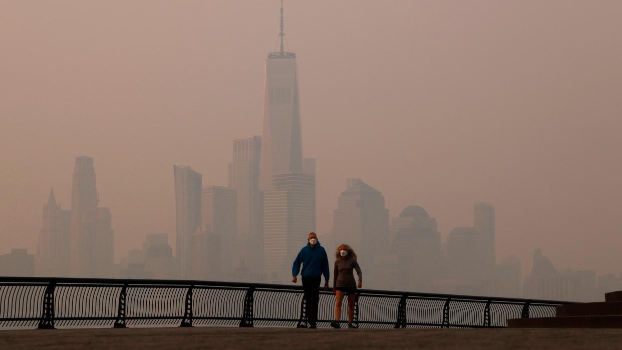  Smoke along the Hudson River with two people walking. 