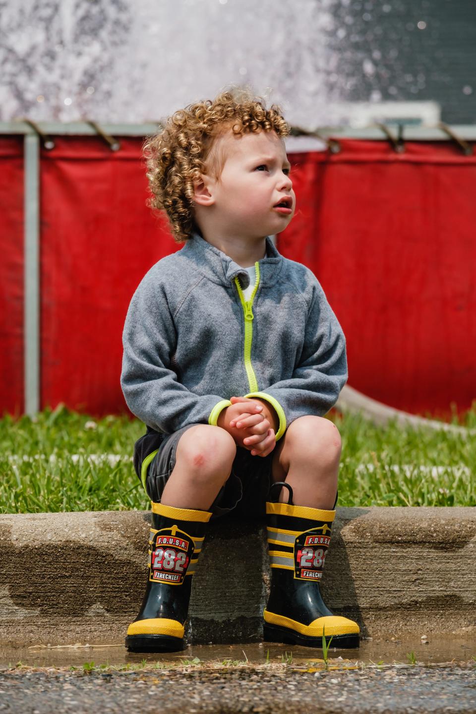 Ezra Young, 2, watches firefighters operate a ladder truck during the celebration of the Dover Fire Department's 150th year of operation, Sunday, May 21 at the  north station.
