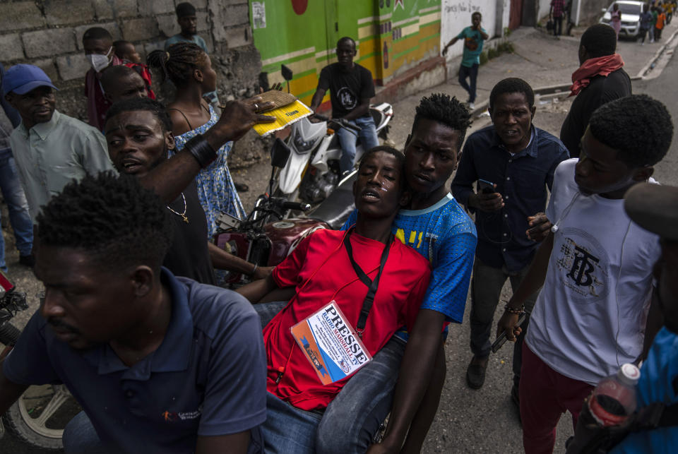 FILE - People help a journalist overcome by tear gas, launched by police during a protest over the death of journalist Romelson Vilsaint, in Port-au-Prince, Haiti, Sunday, Oct. 30, 2022. According to a report released Tuesday, Jan. 24, 2023, by the New York-based Committee to Protect Journalists, killings of journalists around the world jumped by 50% in 2022 compared to the previous year, driven largely by murders of reporters in the three deadliest countries: Ukraine, Mexico and Haiti. (AP Photo/Ramon Espinosa, File)