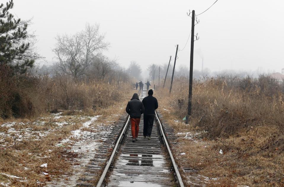 Migrants walk along train tracks close to the northern Serbian town of Subotica, near the border between Serbia and Hungary, Wednesday, Feb. 1, 2017. Thousands of migrants have been stranded in Serbia and looking for ways to cross illegally into the European Union. (AP Photo/Darko Vojinovic)