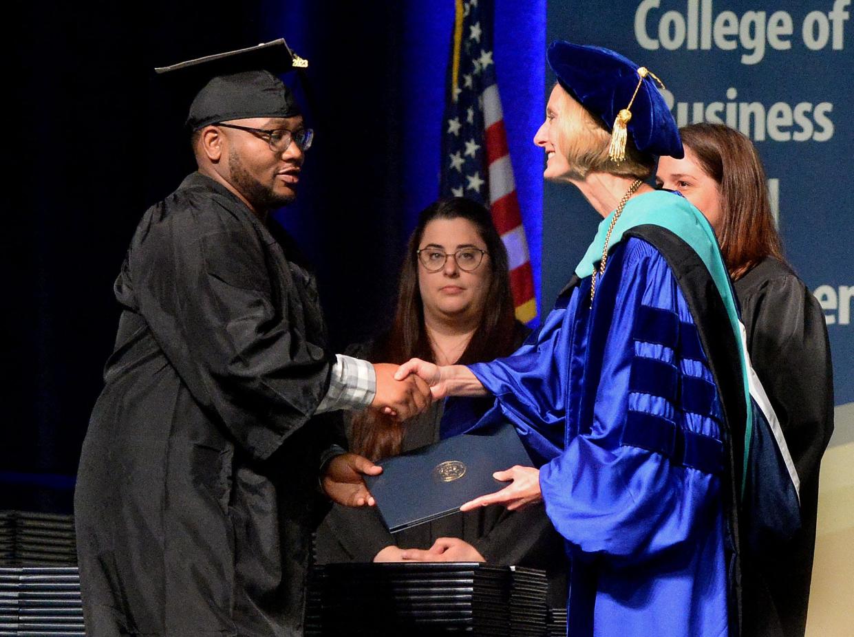 Rashawn Jones, left, receives his Bachelor of Arts diploma from Chancellor Janet Gooch during the University of Illinois Springfield Commencement ceremony Saturday, May 13, 2023.