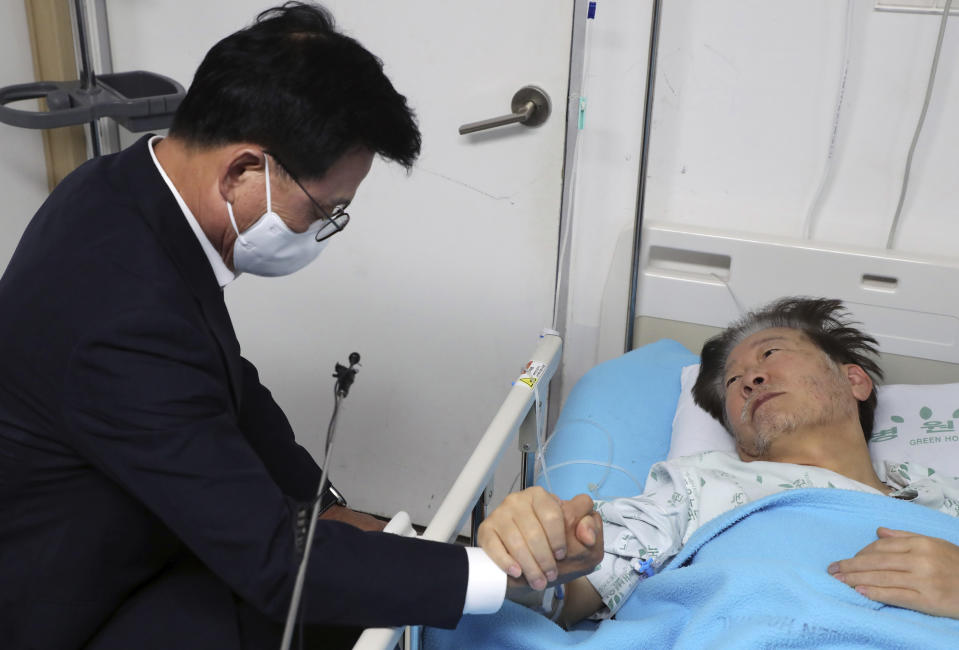 South Korea's main opposition Democratic Party leader Lee Jae-myung, right, holds a hand of his party member Park Kwang-on at a hospital in Seoul, South Korea, Thursday, Sept. 21, 2023. In a surprise outcome, South Korea’s opposition-controlled parliament on Thursday voted to pass a motion submitted by the government that allows for the potential arrest of the country’s leading opposition figure, Lee Jae-myung, who faces a widening investigation over corruption allegations.(Yonhap via AP)