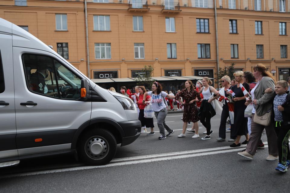 Belarusian opposition supporters block the way for a police bus as they rally in the center of Minsk, Belarus, Sunday, Aug. 30, 2020. Opposition supporters whose protests have convulsed the country for two weeks aim to hold a march in the capital of Belarus. (AP Photo)