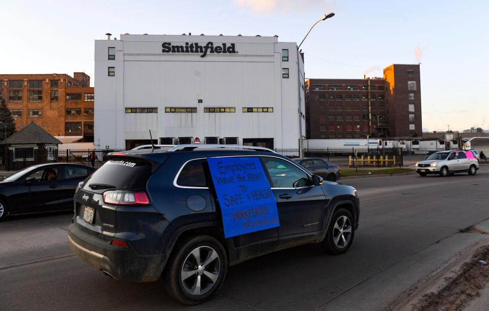 A car sporting a sign calling for a safe and healthy workplace drives past Smithfield Foods Inc. in Sioux Falls, S.D., on April 9, 2020, during a protest on behalf of employees after many workers complained of unsafe working conditions due to the COVID-19 outbreak.