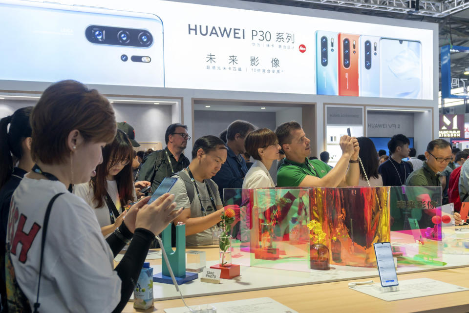 Visitors look at a display of smartphones from Chinese technology firm Huawei at the Consumer Electronics Show in Shanghai, Tuesday, June 11, 2019. Chinese tech giant Huawei said Tuesday it would have become the world's number one smartphone maker by year's end if it were not for "unexpected" circumstances — a hint that pressure from the U.S. may be hurting its sales. (Chinatopix via AP)