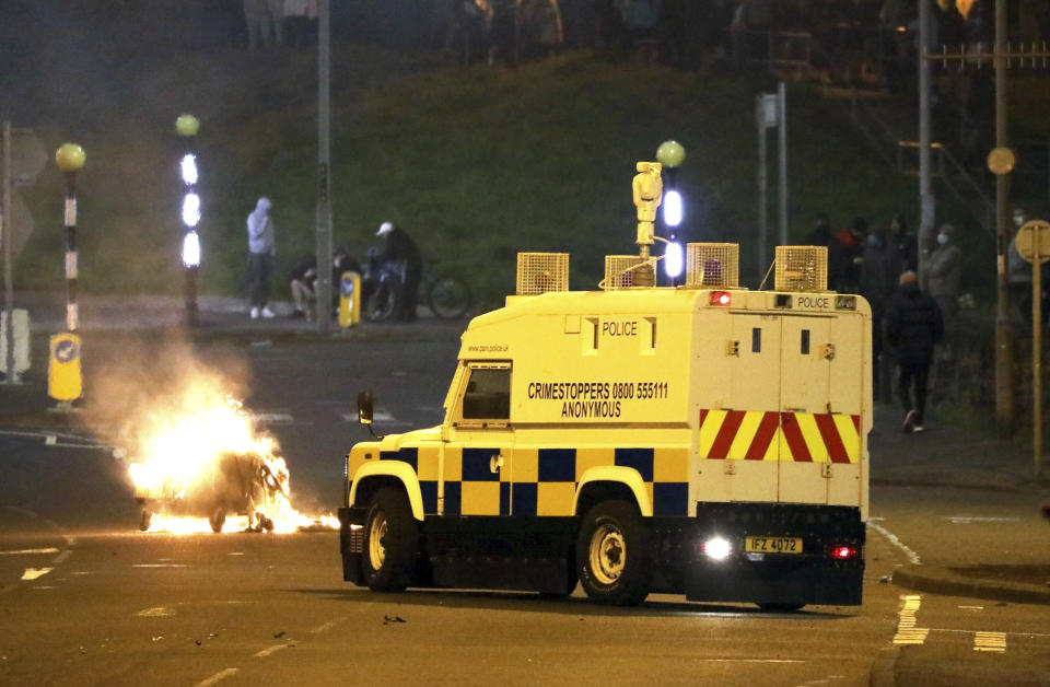 The Police Service of Northern Ireland comes under attack by Loyalists at the Cloughfern roundabout in Newtownabbey, Belfast, Northern Ireland, Saturday, April 3, 2021. Masked men threw petrol bombs and hijacked cars in the Loyalist area North of Belfast. Loyalists and unionists are angry about post-Brexit trading arrangements which they claim have created barriers between Northern Ireland and the rest of the UK. (Peter Morrison/PA via AP)