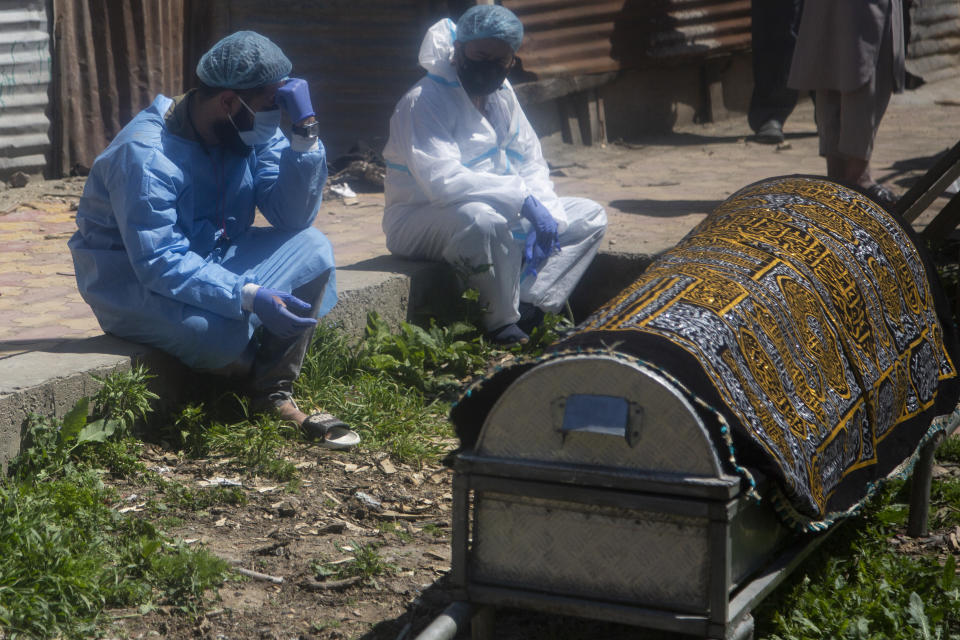Relatives mourn near a coffin containing the body of a person who died of COVID-19 in Srinagar, Indian controlled Kashmir, Sunday, April 25, 2021. India’s crematoriums and burial grounds are being overwhelmed by the devastating new surge of infections tearing through the populous country with terrifying speed, depleting the supply of life-saving oxygen to critical levels and leaving patients to die while waiting in line to see doctors. (AP Photo/Mukhtar Khan)