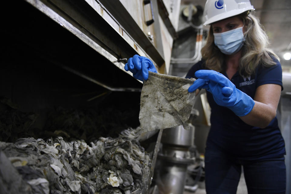 In this May 28, 2020, file photo Lyn Riggins, WSSC Water spokesperson, holds up a wipe that was collected along with other debris at a pumping station in Washington. Sewer systems are battling the "wipe monster" from all the wipes and other debris since pandemic that are clogging up pumping stations. (AP Photo/Susan Walsh)