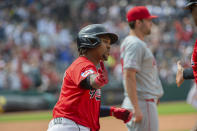 Cleveland Guardians' Jose Ramirez is congratulated by Guardians first base coach Sandy Alomar Jr., far right, after hitting a two-run home run off Los Angeles Angels starting pitcher Griffin Canning, rear, during the sixth inning of a baseball game in Cleveland, Sunday, May 5, 2024. (AP Photo/Phil Long)