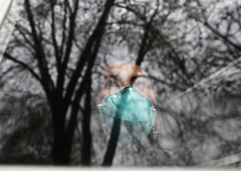 Francy Sandoval looks outside from her home in Melrose Park, Ill., Thursday, April 23, 2020. At the age of 24, Sandoval has unwittingly become the sole breadwinner for her family, after her mom, dad and brother — a nanny, a painter and a server — all lost their jobs in the coronavirus pandemic. (AP Photo/Nam Y. Huh)