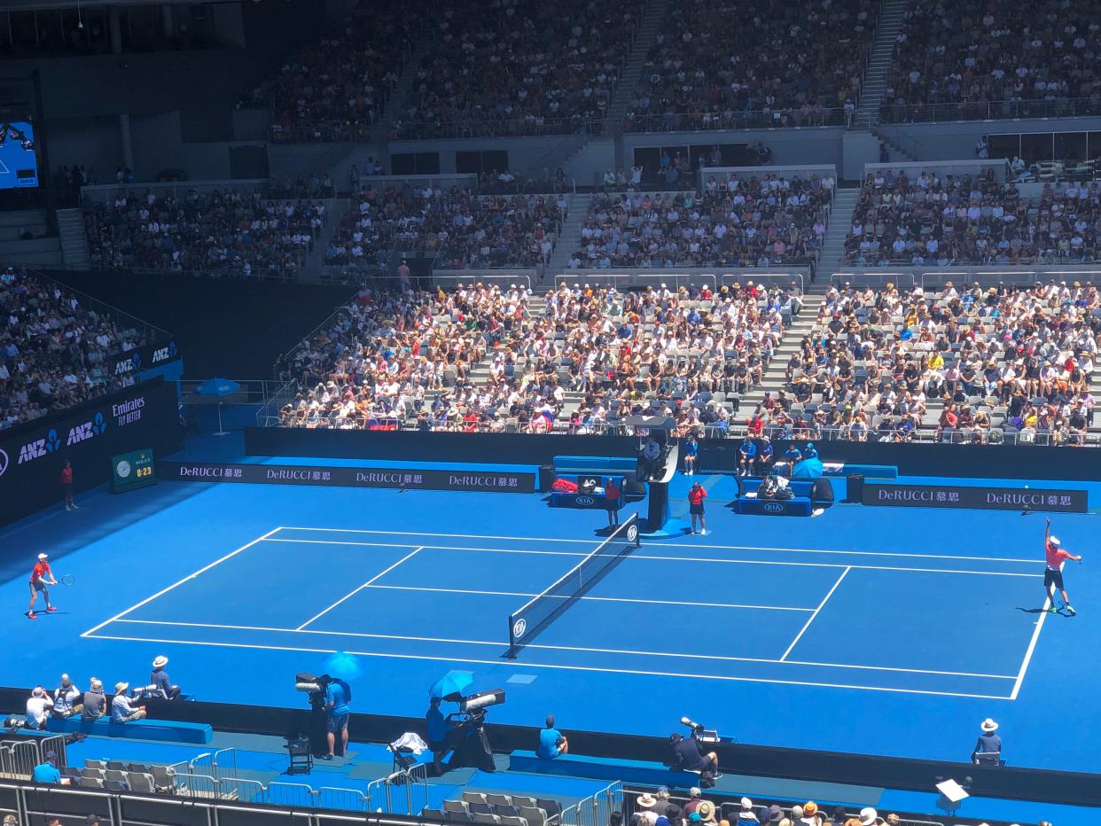 Tennis players competing on a blue court at the Australian Open.