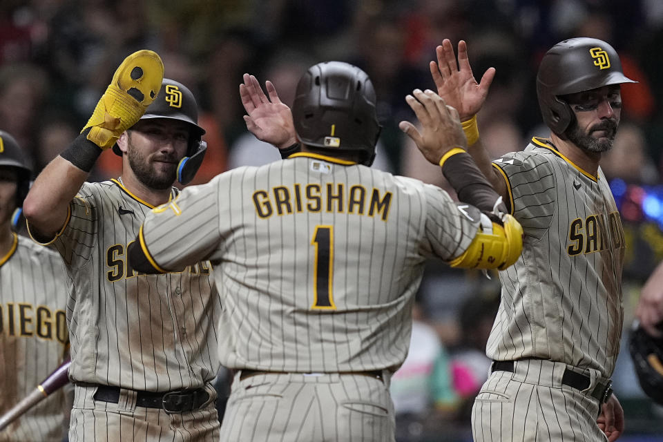 San Diego Padres' Trent Grisham (1) celebrates with Matthew Batten and Matt Carpenter after hitting a three-run home run during the eighth inning of a baseball game against the Houston Astros, Friday, Sept. 8, 2023, in Houston. (AP Photo/Kevin M. Cox)