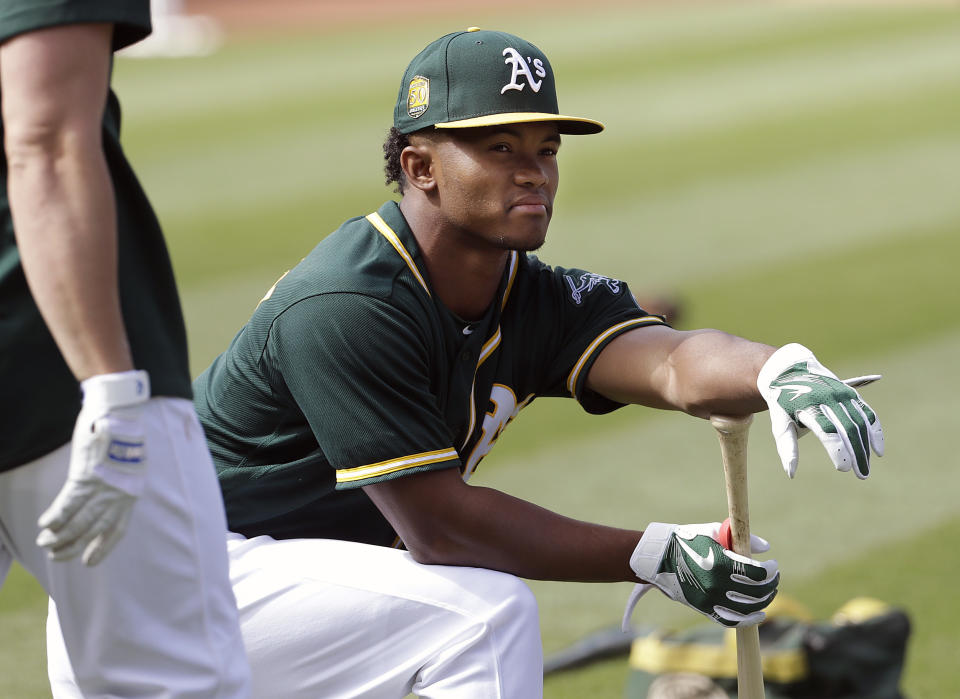 FILE - In this Friday, June 15, 2018 file photo, Oakland Athletics draft pick Kyler Murray waits to hit during batting practice before a baseball game between the Athletics and the Los Angeles Angels in Oakland, Calif. Kyler Murray suddenly has a bunch of new fans in the Oakland Athletics organization, even if they cringe watching Heisman Trophy winner play quarterback for Oklahoma. The A's don't want their prized first-round draft pick hurt on the football field because they are counting on him wearing an Oakland jersey come spring training. (AP Photo/Jeff Chiu, File)