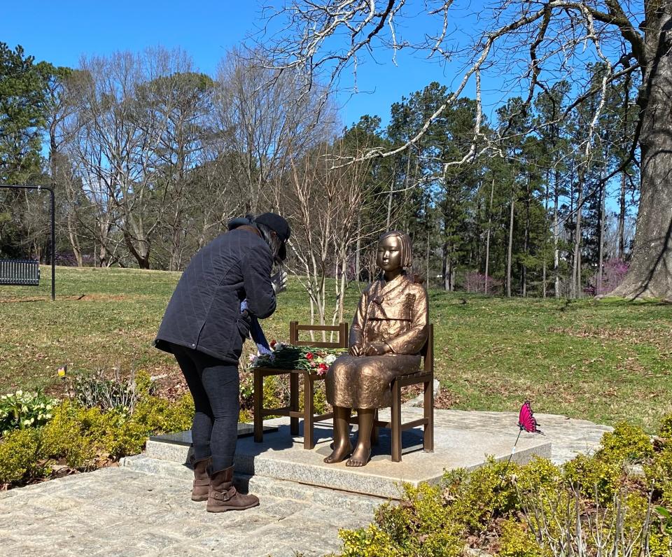 On March 12, a woman places a rose and honors the peace monument in Georgia that honors the 200,000+ girls and women, known as ‘comfort women,’ who were sexually enslaved throughout Asia during World War II.