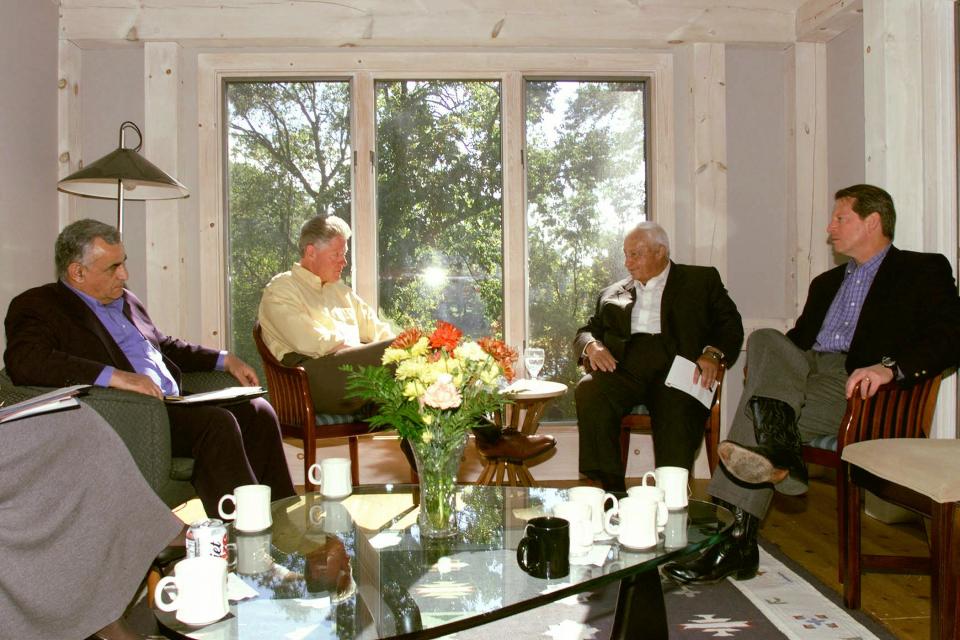 In this file photo, US President Bill Clinton (2nd L) and US Vice President Al Gore (R) meet with Israeli Foreign Minister Ariel Sharon (2nd R), and Israeli Defense Minister Yizahak Mordechai (L) in the O'Brien Cabin 18 October at the Wye River Conference Center during the Middle East Peace talks. Clinton launched an extraordinary all-out push to bring reluctant Israeli and Palestinian leaders into a new peace accord as the Mideast summit went into a fourth day. AFP PHOTO WHITE HOUSE (Photo by WHITE HOUSE / AFP) (Photo by -/WHITE HOUSE/AFP via Getty Images)