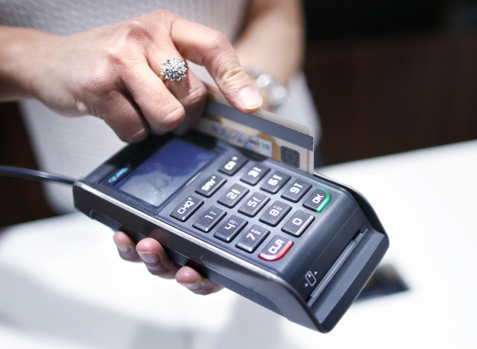 A shop assistant uses an eftpos system at a Specialty Fashion Group owned Katies store in Sydney December 11, 2012. Australia is being invaded by a swathe of foreign retailers, piling pressure on a local industry already battered by weak consumer spending and ruthless internet competition. Picture taken December 11, 2012. REUTERS/Tim Wimborne (AUSTRALIA - Tags: BUSINESS FASHION)