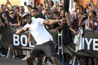 FILE - In this April 2, 2019, file photo, Jamaican sprinter Usain Bolt strikes his now-famous victory pose after defeating a mototaxi in a 50-meter race in Lima, Peru. The retired sprinting great recently had twins, which is keeping him plenty busy. He thinks one of the favorites to win the 100 meters at the Tokyo Games is American Trayvon Bromell. (AP Photo/Martin Mejia, File)