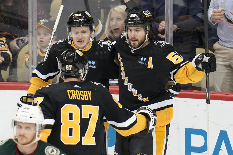 Pittsburgh Penguins' Kris Letang (58) celebrates his goal against the Minnesota Wild with Jake Guentzel (59) and Sidney Crosby (87) during the first period of an NHL hockey in Pittsburgh, Thursday, April 6, 2023. (AP Photo/Gene J. Puskar)