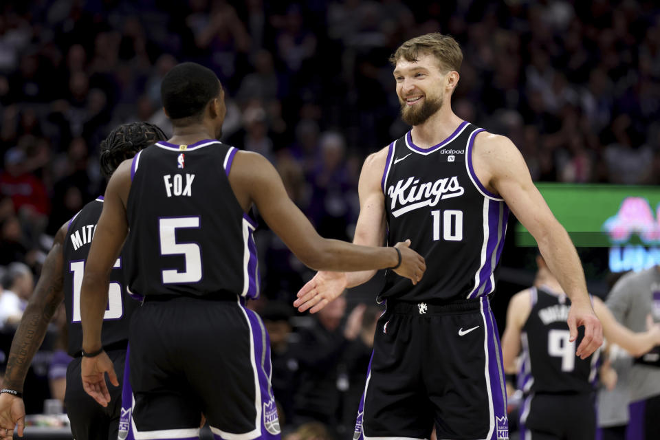 Sacramento Kings forward Domantas Sabonis (10) and guard De'Aaron Fox (5) celebrate during the first half of an NBA basketball game against the San Antonio Spurs in Sacramento, Calif, Thursday, March 7, 2024. (AP Photo/Jed Jacobsohn)