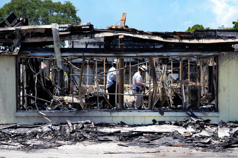 Police investigators work the scene of what remains of the Vero Beach Laundry & Cleaners and Kidz Closet of Vero Beach on Wednesday, May 18, 2022. Both businesses were destroyed in an overnight fire that was reported at 9:15 p.m. Tuesday. A State Fire Marshal investigation is underway to determine the cause.