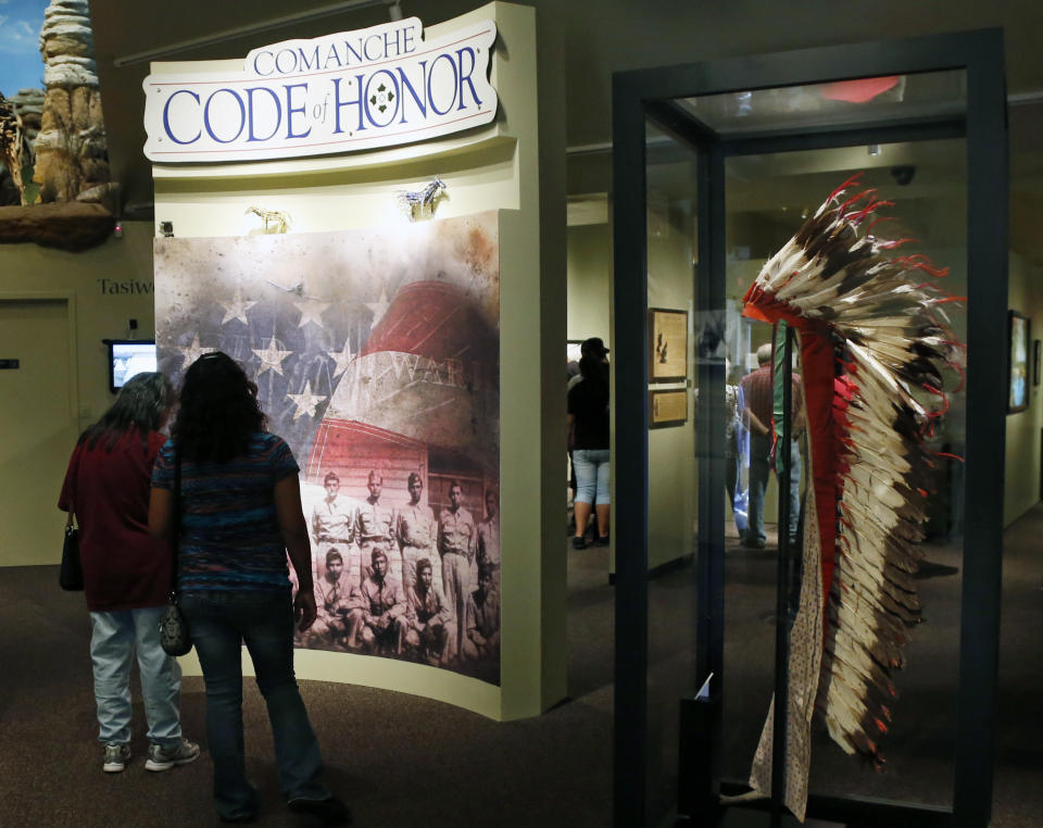 People walk through an exhibit about the Comanche Code Talkers at the Comanche National Museum & Cultural Center in Lawton, Okla, Thursday, Sept. 26, 2013. (AP Photo/Sue Ogrocki)