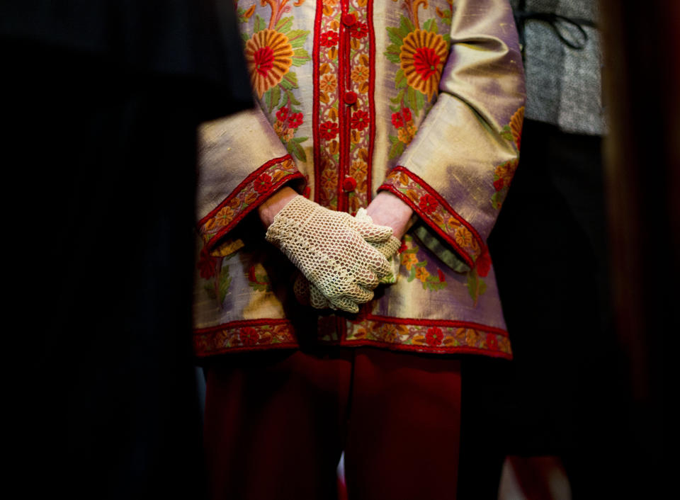 FILE - Associate Justice Ruth Bader Ginsburg, center, stands during the annual Women's History Month reception at Statuary Hall on Capitol Hill in Washington, March 18, 2015. A collection of nearly 100 items is being sold in an online auction that begins Wednesday, Sept. 7, 2022, and runs through Sept. 16, including a pair of cream-colored gloves owned by Ginsburg, not the pair shown above. It concludes just before the two-year anniversary of Ginsburg's death at 87. The proceeds will benefit SOS Children’s Villages, an organization that supports vulnerable children around the world. (AP Photo/Pablo Martinez Monsivais, File)