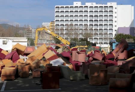 Old sofas are piled next to an excavator in an area outside a hotel in the holiday resort of Magaluf, on the Spain's island of Mallorca, January 23, 2016. REUTERS/Enrique Calvo