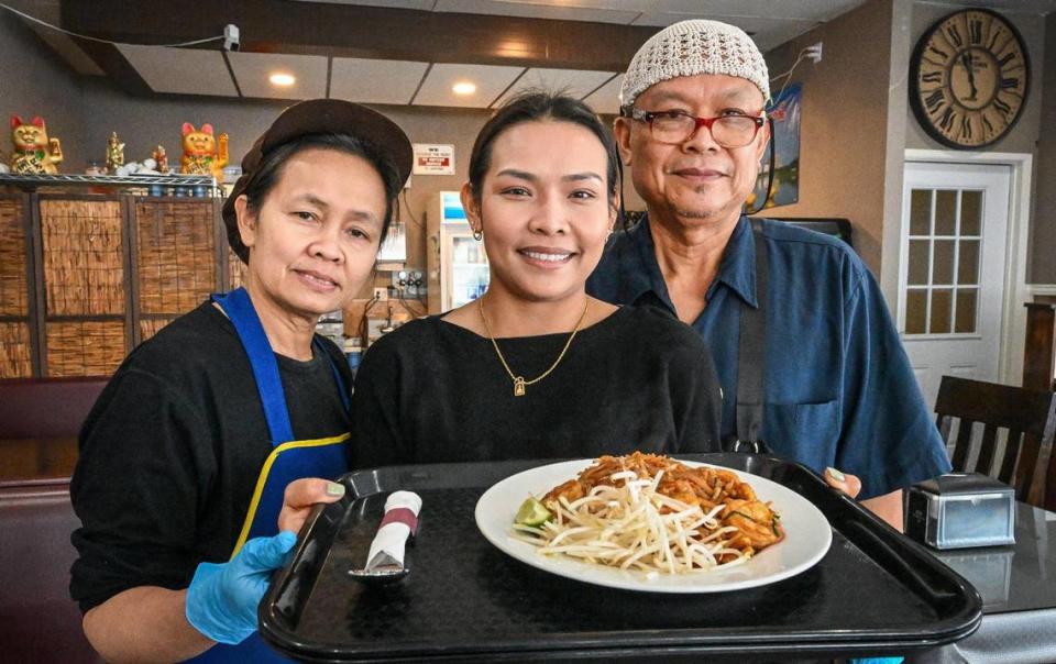 Bo Sringongkhot, center, holds up a pad Thai combination plate with her parents Suphaka, left, and Narong at their Thai restaurant U-D Thai, which they opened at Kings Canyon Road and Maple Avenue in Fresno last year.