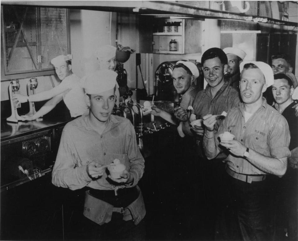 Navy sailors are seen enjoying ice cream aboard a tender while their submarine gets serviced.