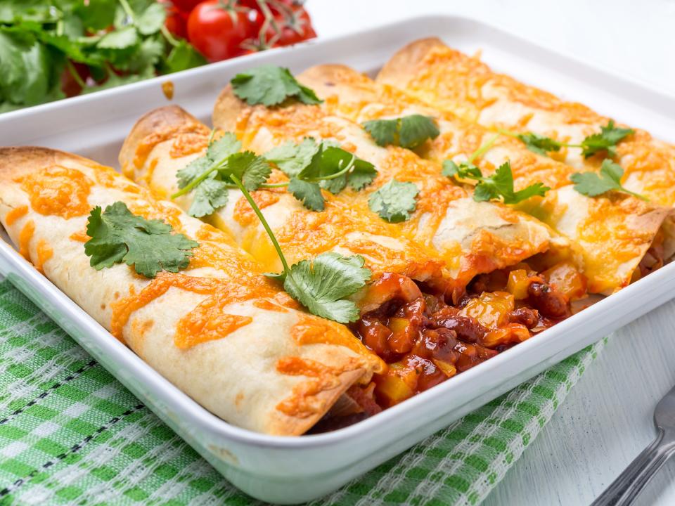 five enchiladas covered in cheese