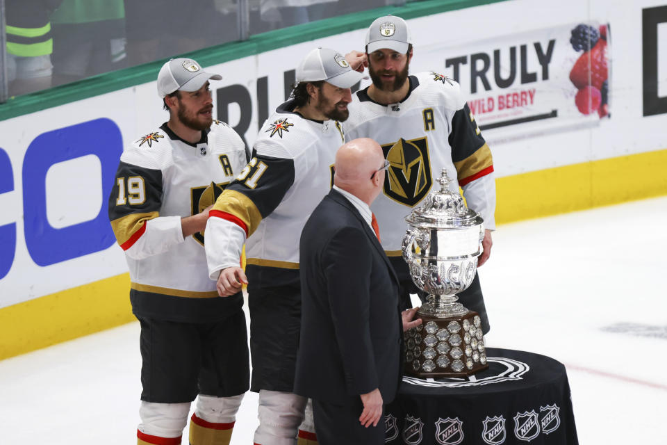 Vegas Golden Knights players Reilly Smith, left, Mark Stone, back center, and Alex Pietrangelo pose with deputy commissioner of the NHL Bill Daly, front, after winning Game 6 of the NHL hockey Stanley Cup Western Conference finals against the Dallas Stars, Monday, May 29, 2023, in Dallas. (AP Photo/Gareth Patterson)