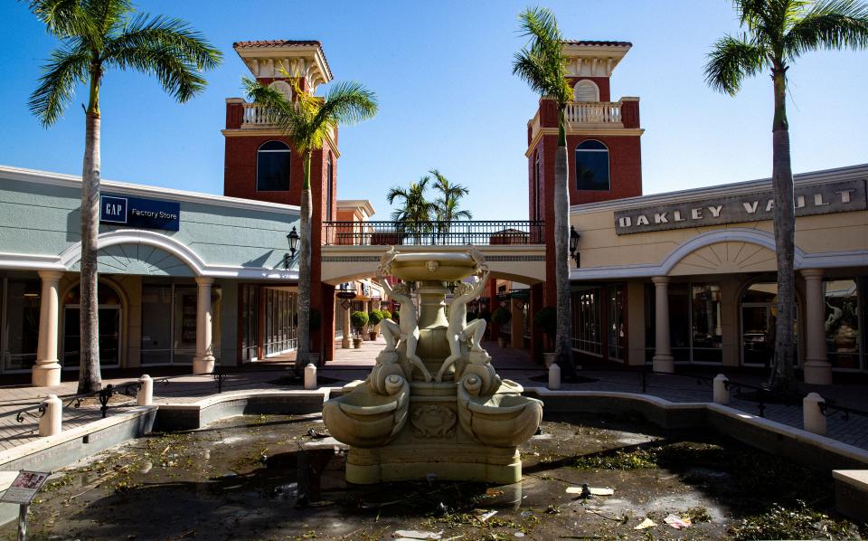 A statue with a drained fountain and debris is shown at the Miromar Outlets in Estero, Fla. following Hurricane Ian on Oct. 5, 2022. 