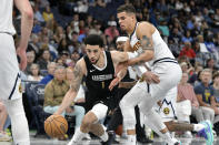 Memphis Grizzlies guard Scotty Pippen Jr. (1) handles the ball against Denver Nuggets forward Michael Porter Jr., right, in the first half of an NBA basketball game Sunday, April 14, 2024, in Memphis, Tenn. (AP Photo/Brandon Dill)