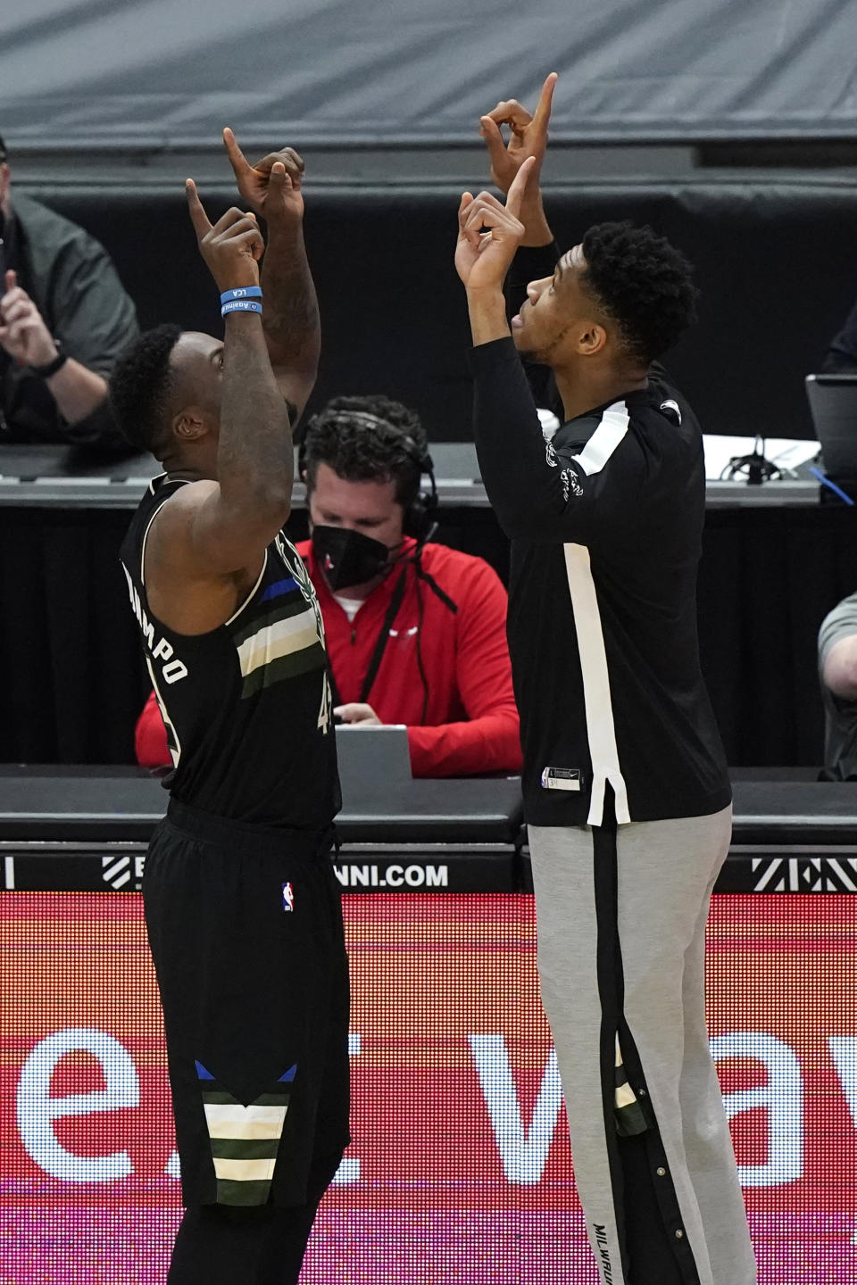 Milwaukee Bucks players Thanasis Antetokounmpo, left, and Giannis Antetokounmpo, right, give five before an NBA basketball game against the Chicago Bulls in Chicago, Sunday, May 16, 2021. (AP Photo/Nam Y. Huh)