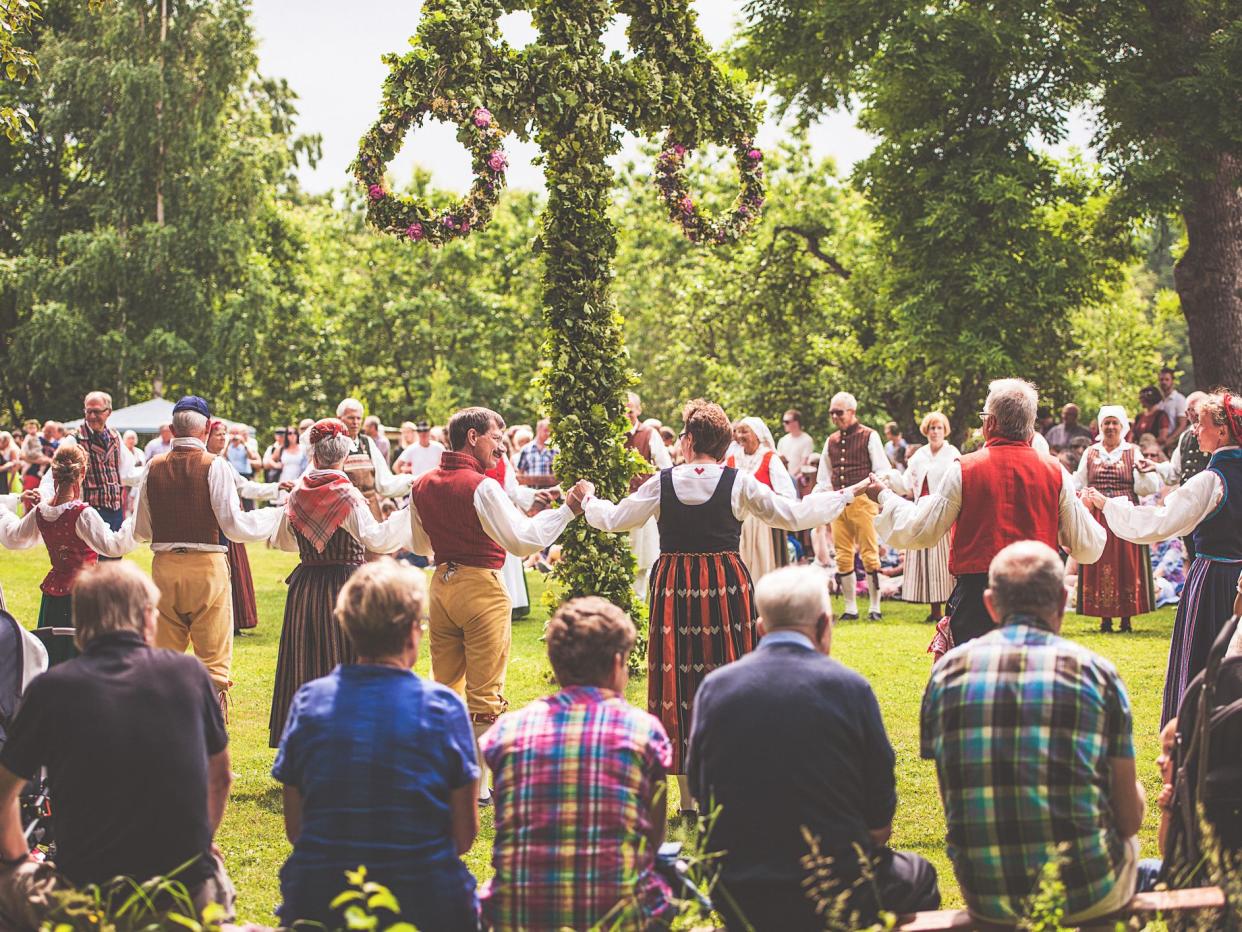 Nykil, Sweden-June 21, 2013: Swedish midsummer, midsommar, celebration in Nykil, östergötland. Typically clothed swedish folk dancers dancing around a midsummer pole.